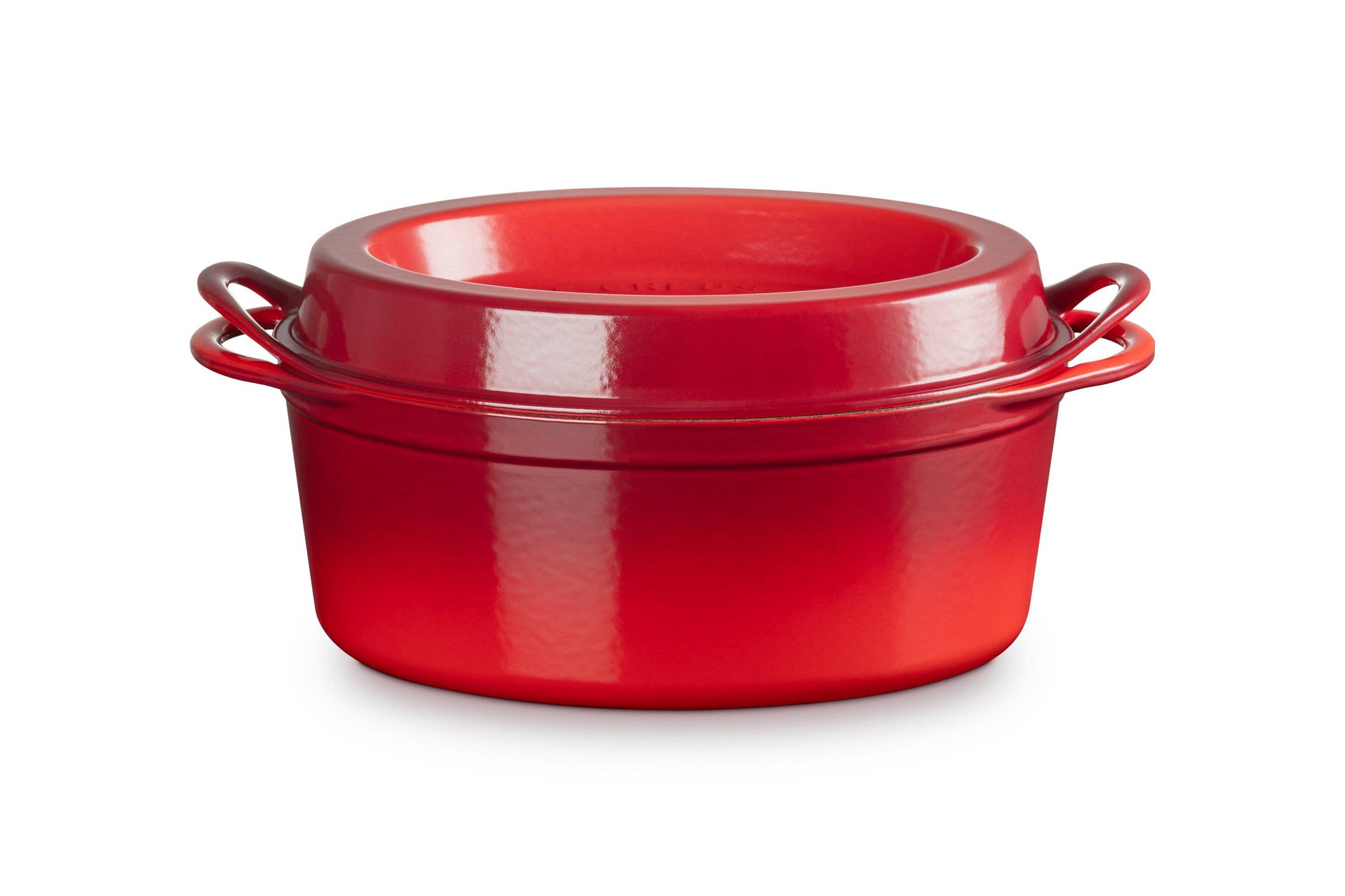 Cocotte Le Creuset en fonte émaillée de couleur orange volcanique posée sur une table de cuisine