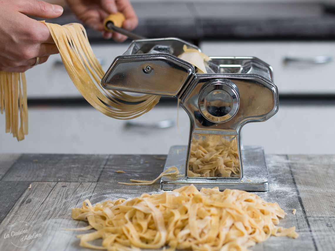 Nids de tagliatelles fraîches maison posés sur un plan de travail fariné